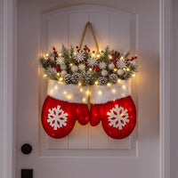 Red mitten Christmas wreath with lights, pine, red berries and snowflakes hanging on a white front door